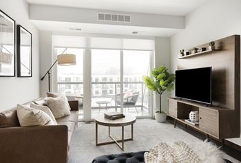 a living room with a couch and a tv and a balcony